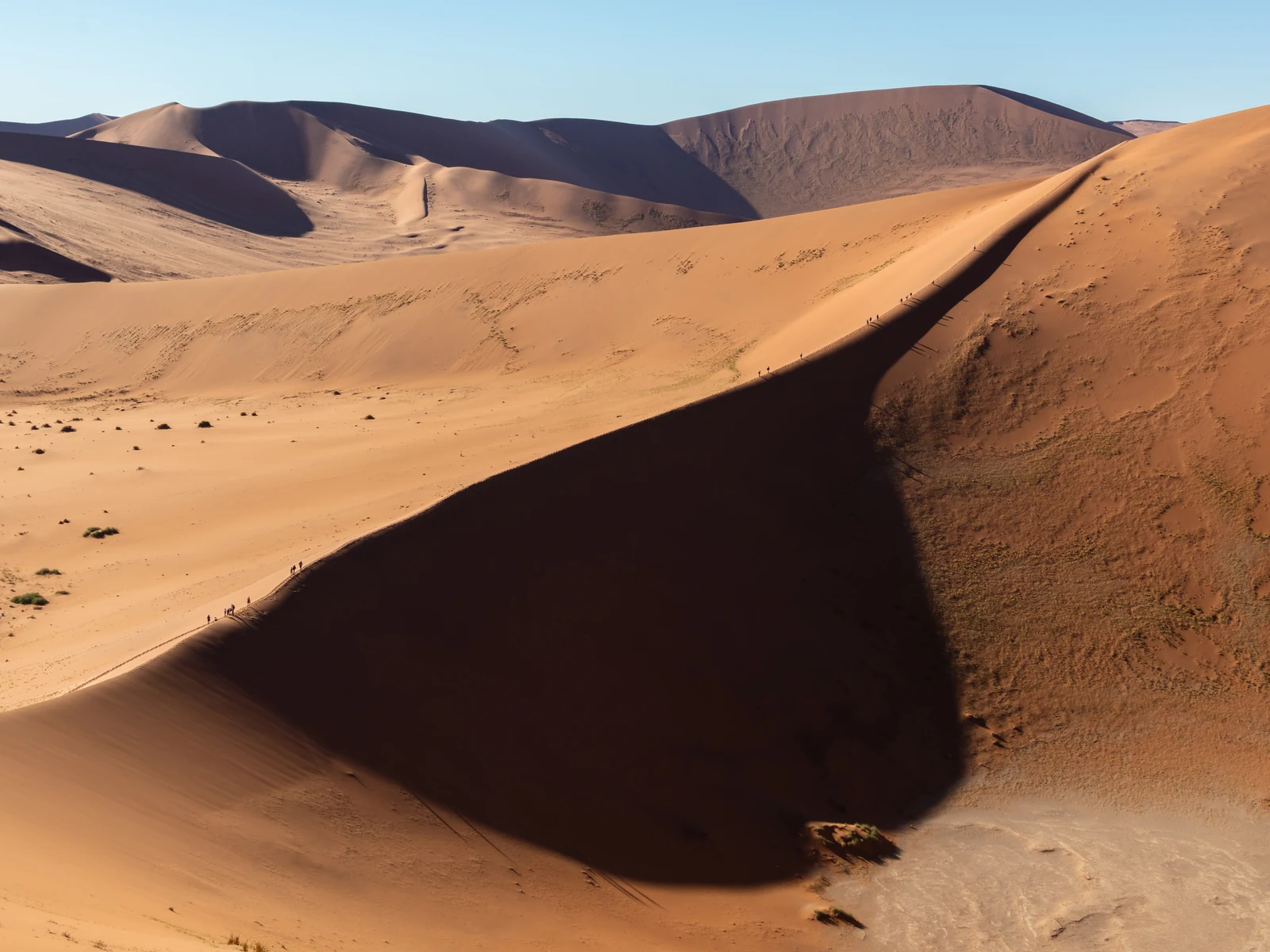 A sharp shadow boundary on a dune in the Sossusvlei area, with more dunes in the distance